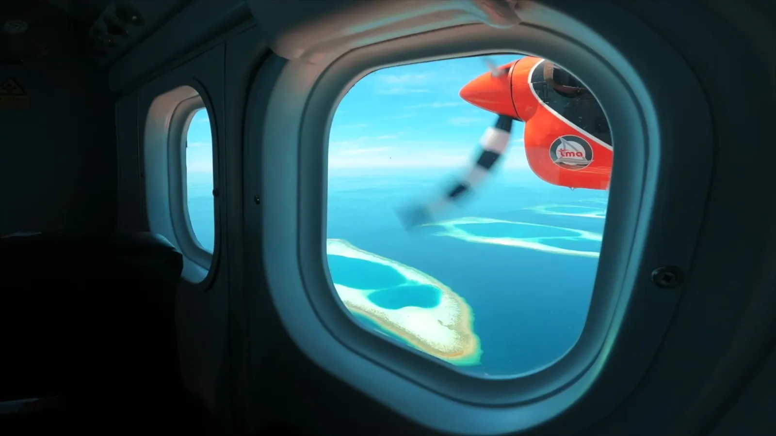 From the seaplane window: the propeller and the atolls below