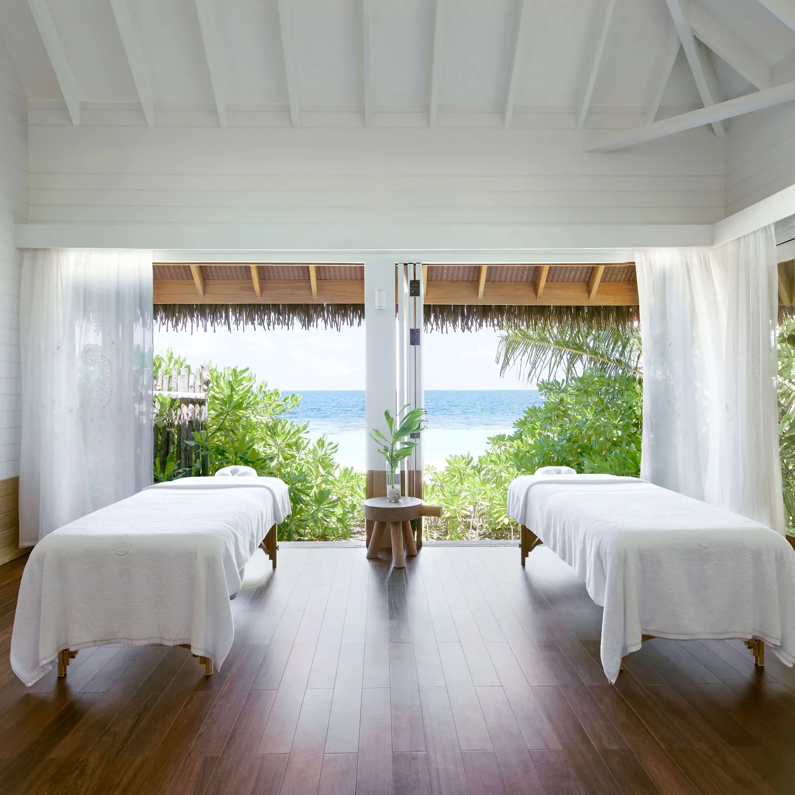 2 massage tables in the white pavilion open to the greenery and the sea