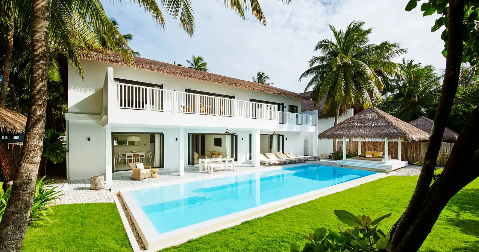 The 2-storey COMO Residence, with its long pool on the lawn and palms.