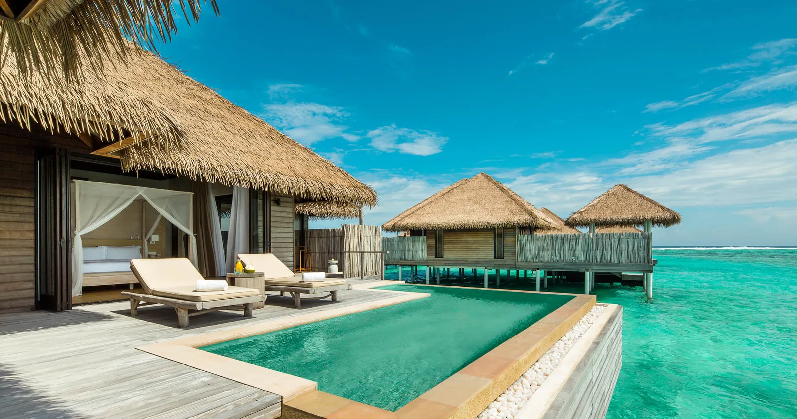 A Water Villa’s pool on the deck above the lagoon, with other water villas behind.