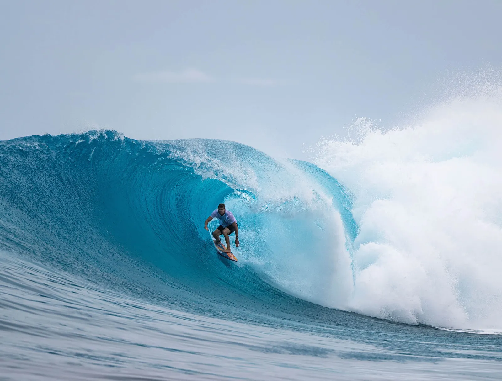 A surfer inside the barrel of a wave breaking over the reef.
