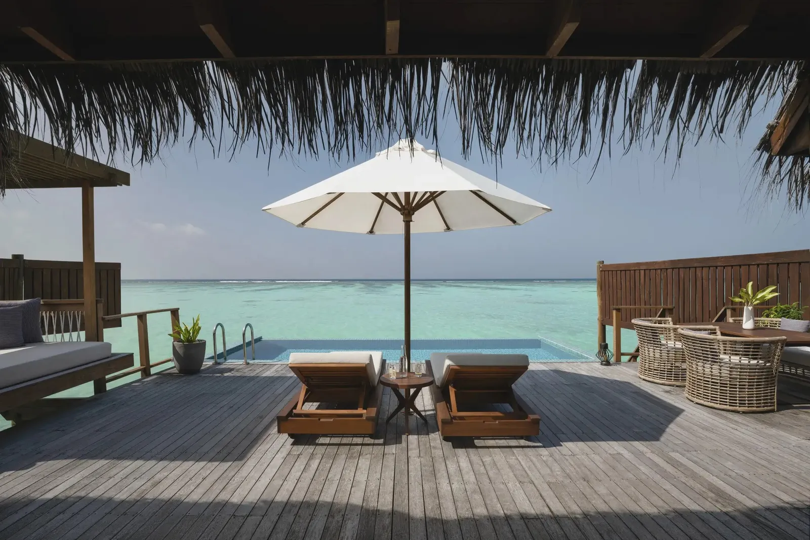 A Premier Water Villa with Pool’s deck, pool and parasol