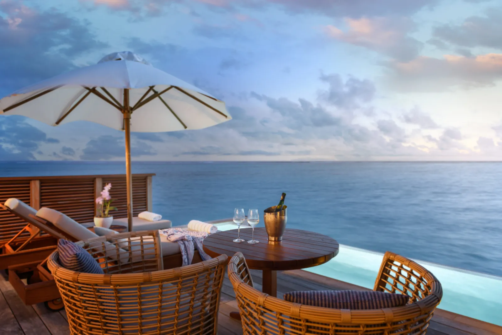 A Sunset Water Villa with Pool’s deck, parasol and pool