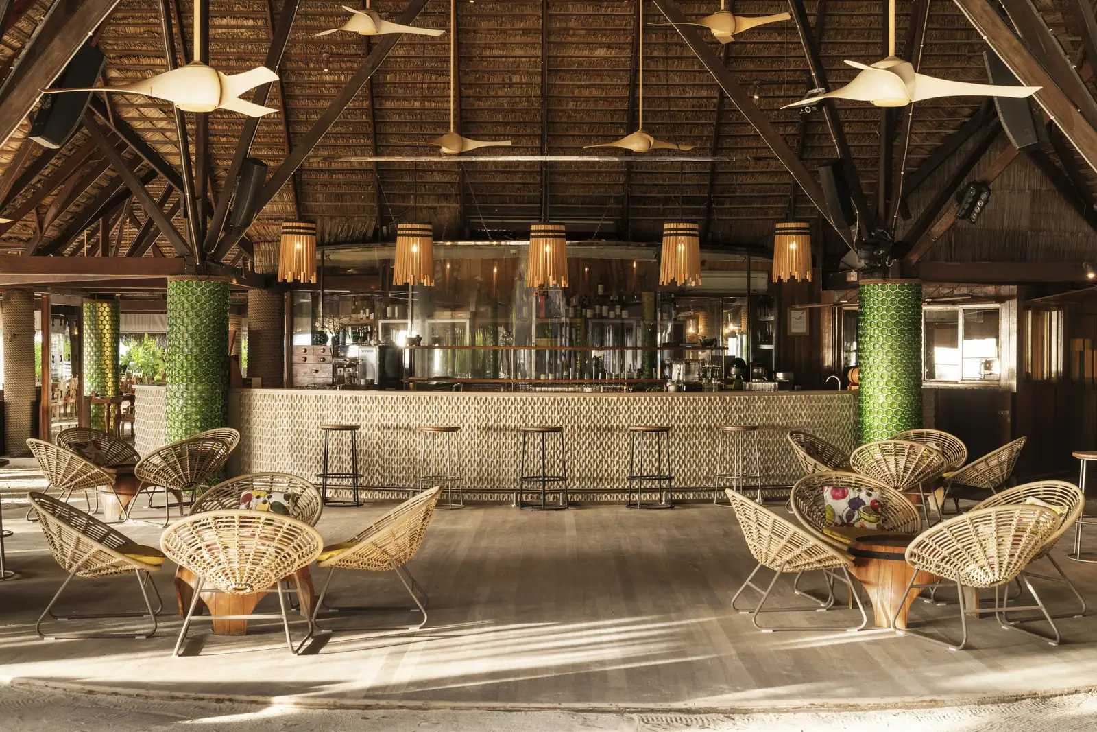 The Manta Bar: the counter, wicker chairs and a sand floor under the timber roof
