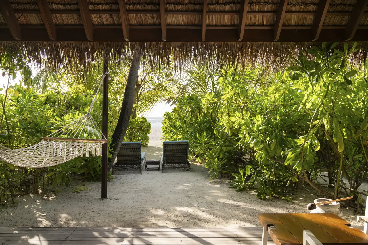 A Beach Villa terrace with a hammock and loungers, the path through the greenery to the beach