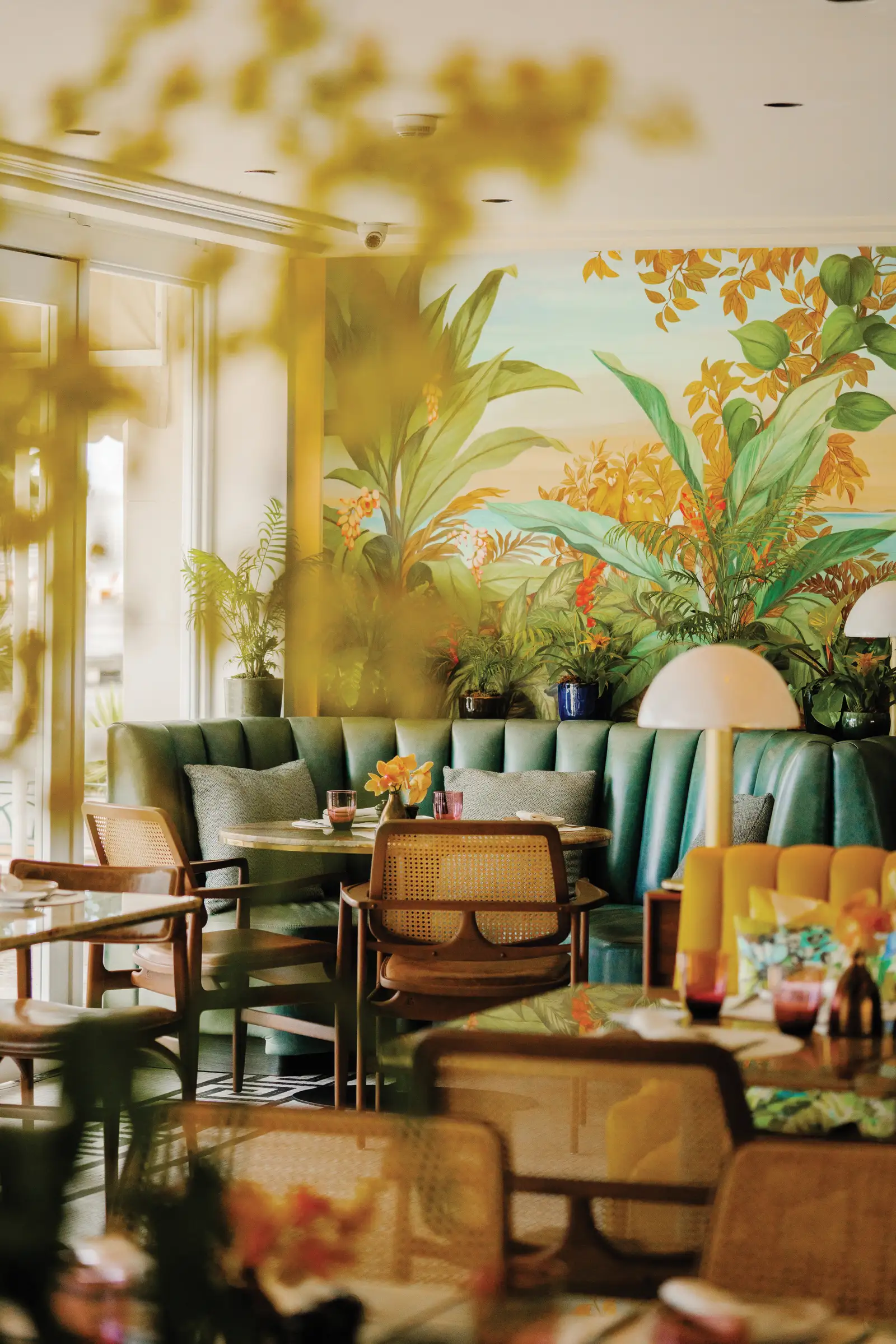 Pérgula con sedute verdi, fiori e pareti tropicali