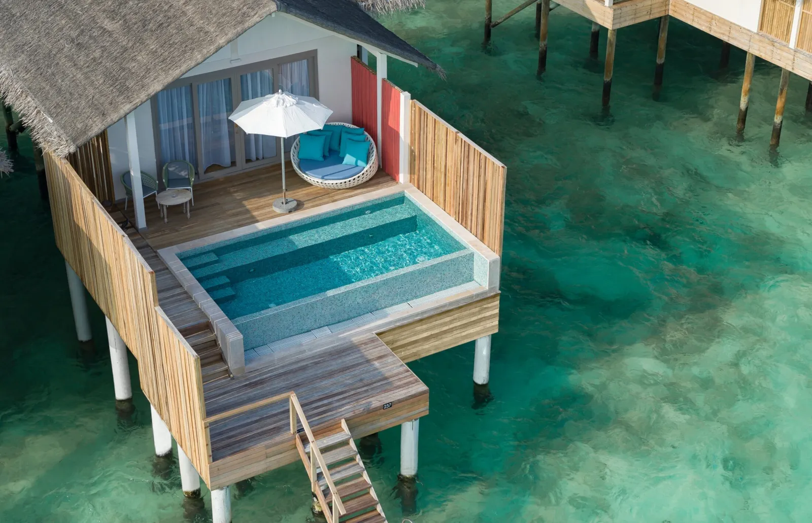 A Lagoon Pool Villa from above, with the pool on its deck, the round daybed and the ladder down into the lagoon.