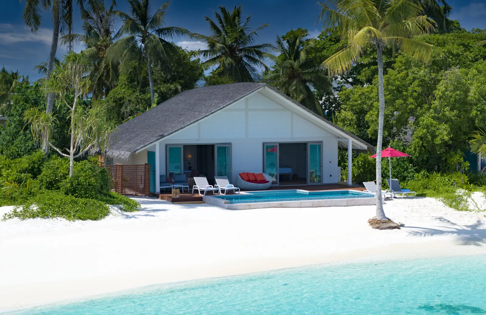 The Two Bedroom Family Beach Pool Villa facing the beach, its pool and loungers a few steps from the sea.