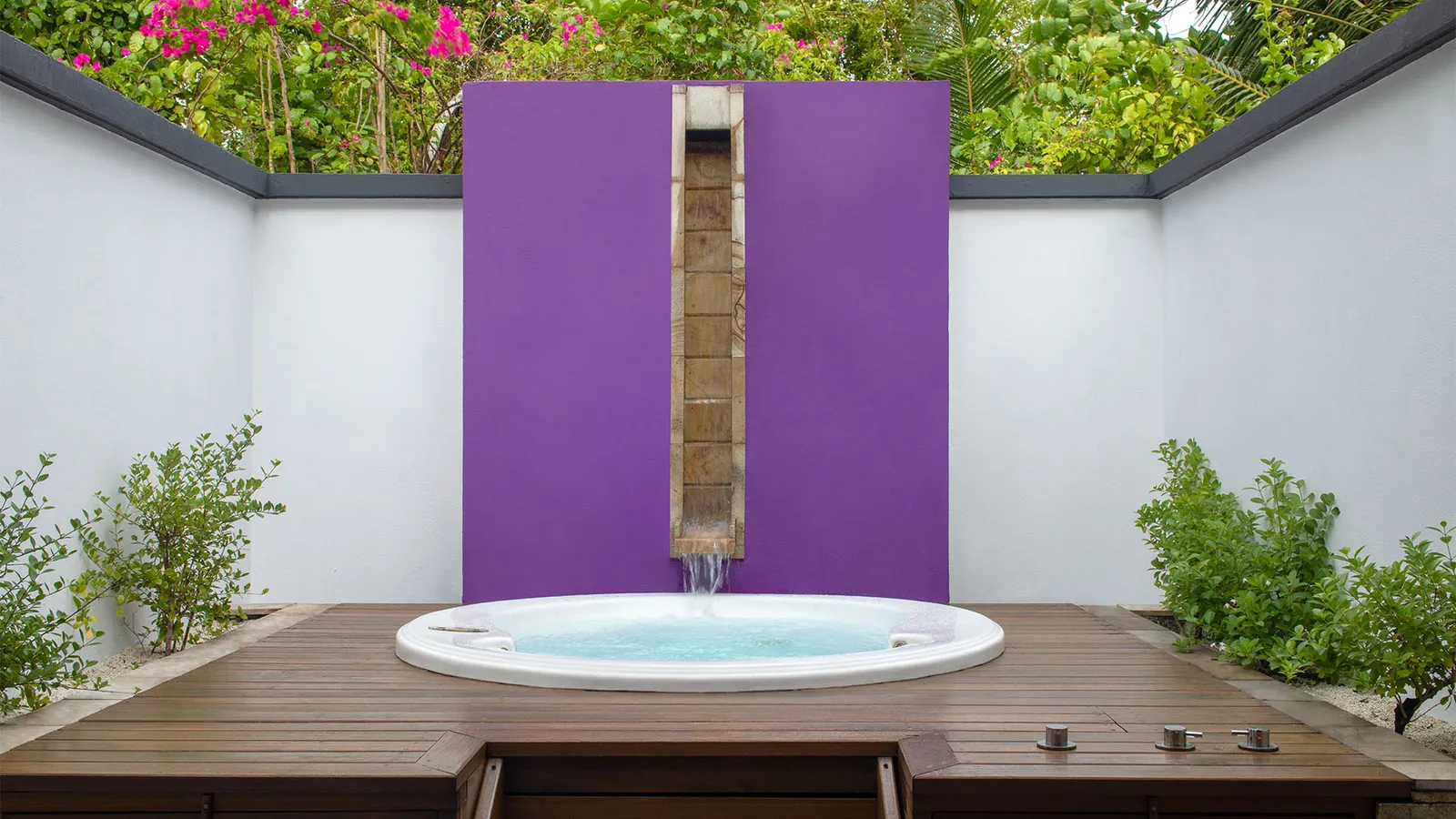 The open-air bathroom courtyard of a Beachfront Jet Pool Villa, with the round jet tub beneath the shower.