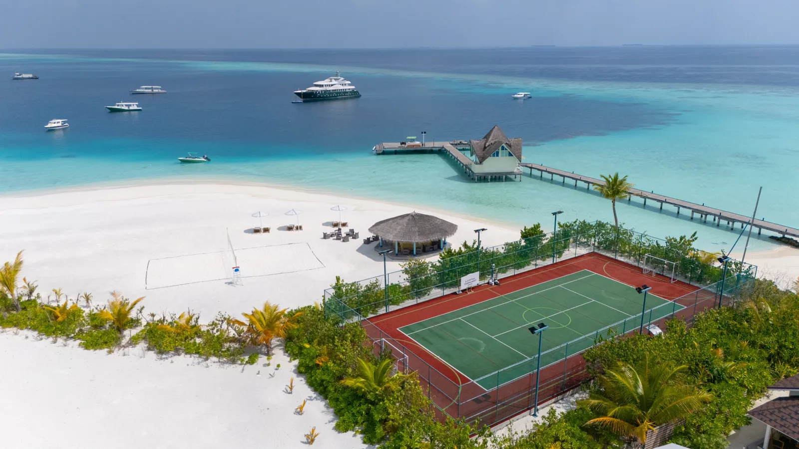 The multi-purpose court by the beach, with the jetty and boats in the lagoon.