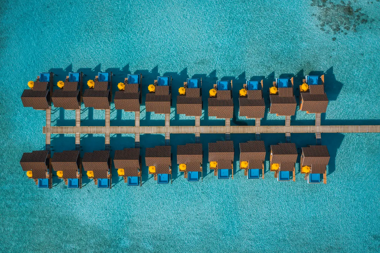 The Pool Water Villas from above, in 2 rows either side of the jetty, each with its pool.