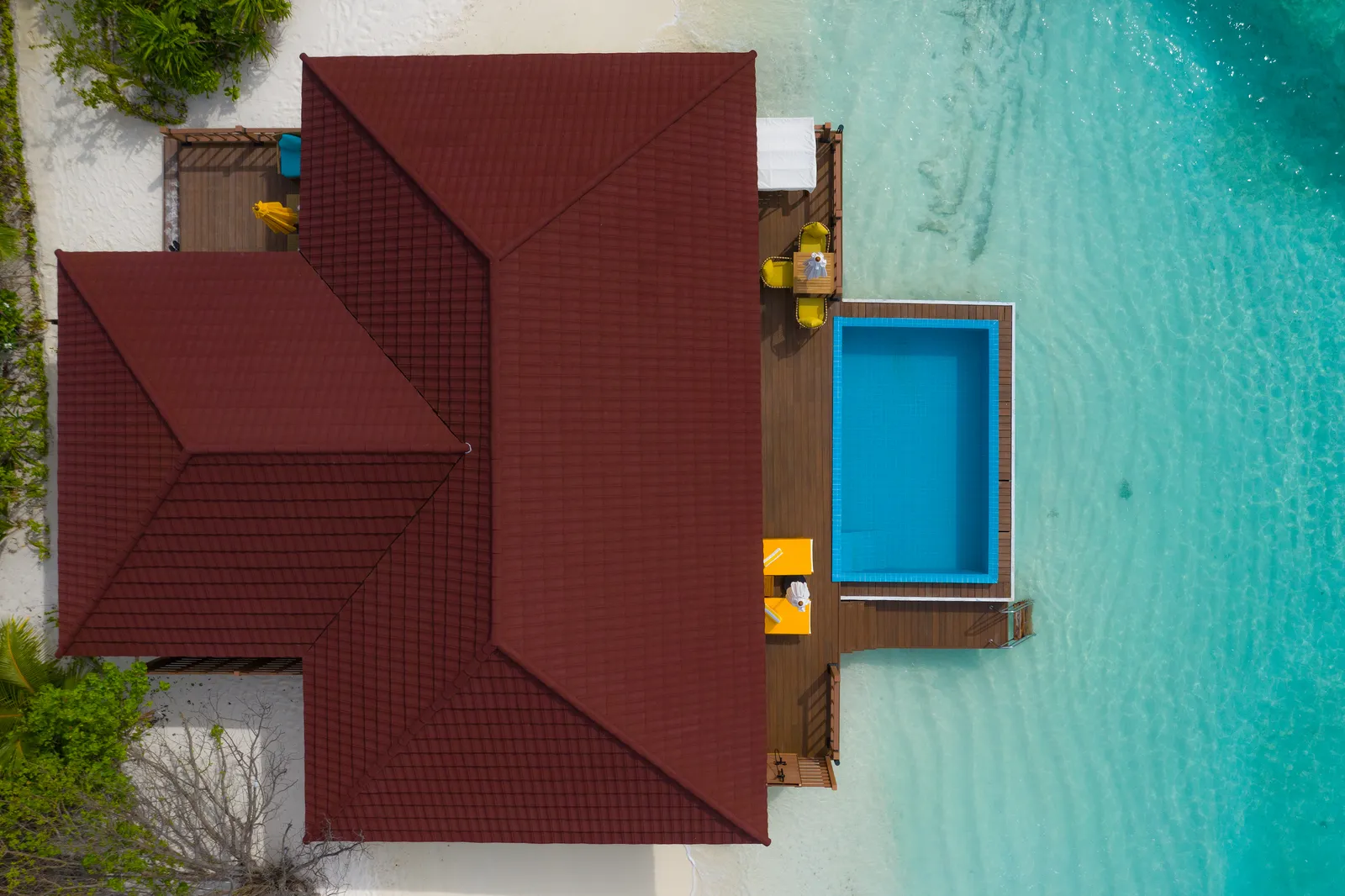 The Sangu Suite from above: its large red roof and the pool on the deck over the lagoon.
