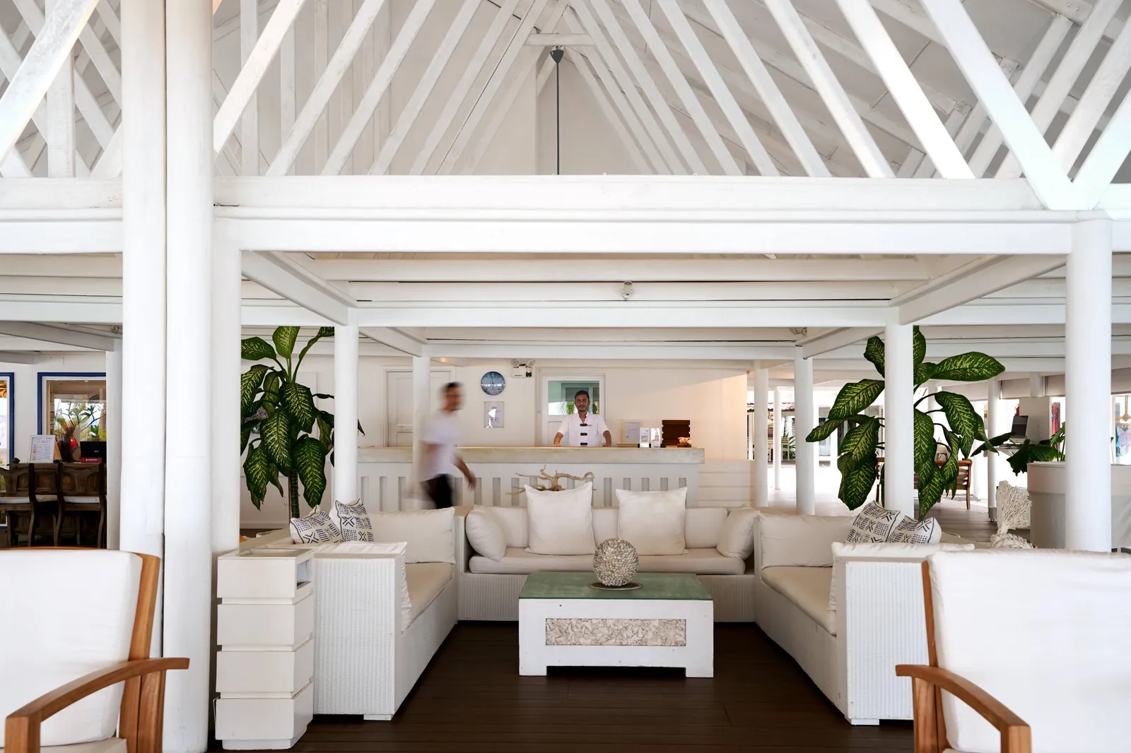 Athuruga’s open lobby, with a white sofa under the white beams and plants.