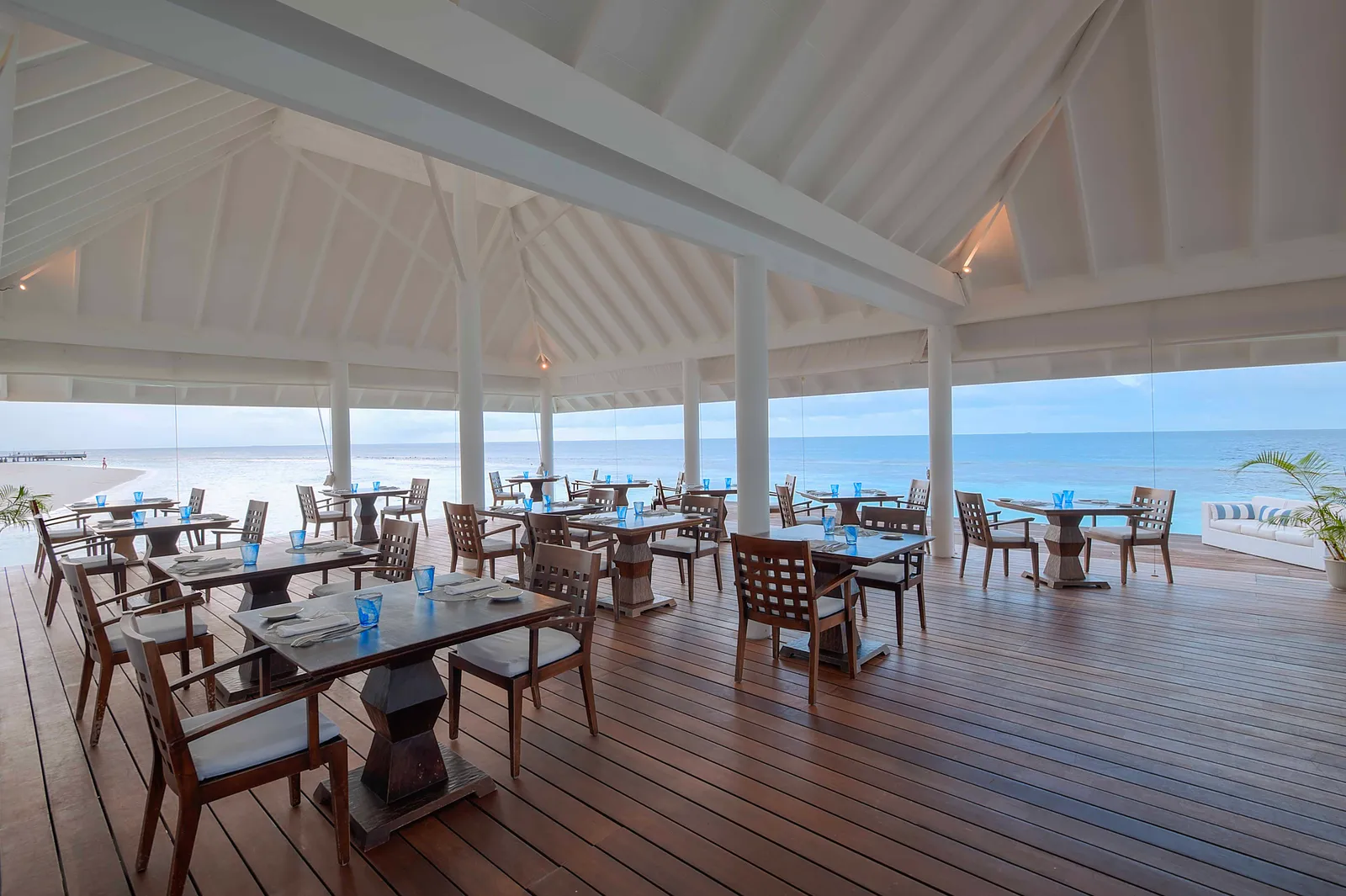 Thari’s wooden deck over the water, its tables laid and the open sea beyond the rail.