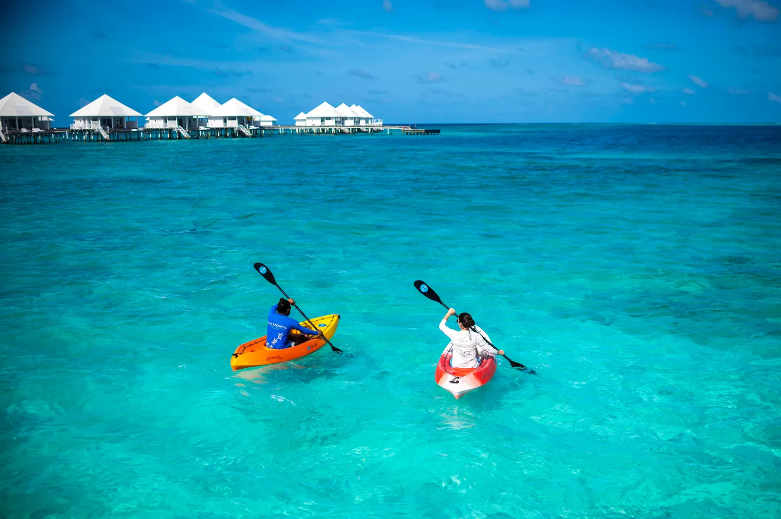 2 kayaks in the lagoon in front of the row of water villas.