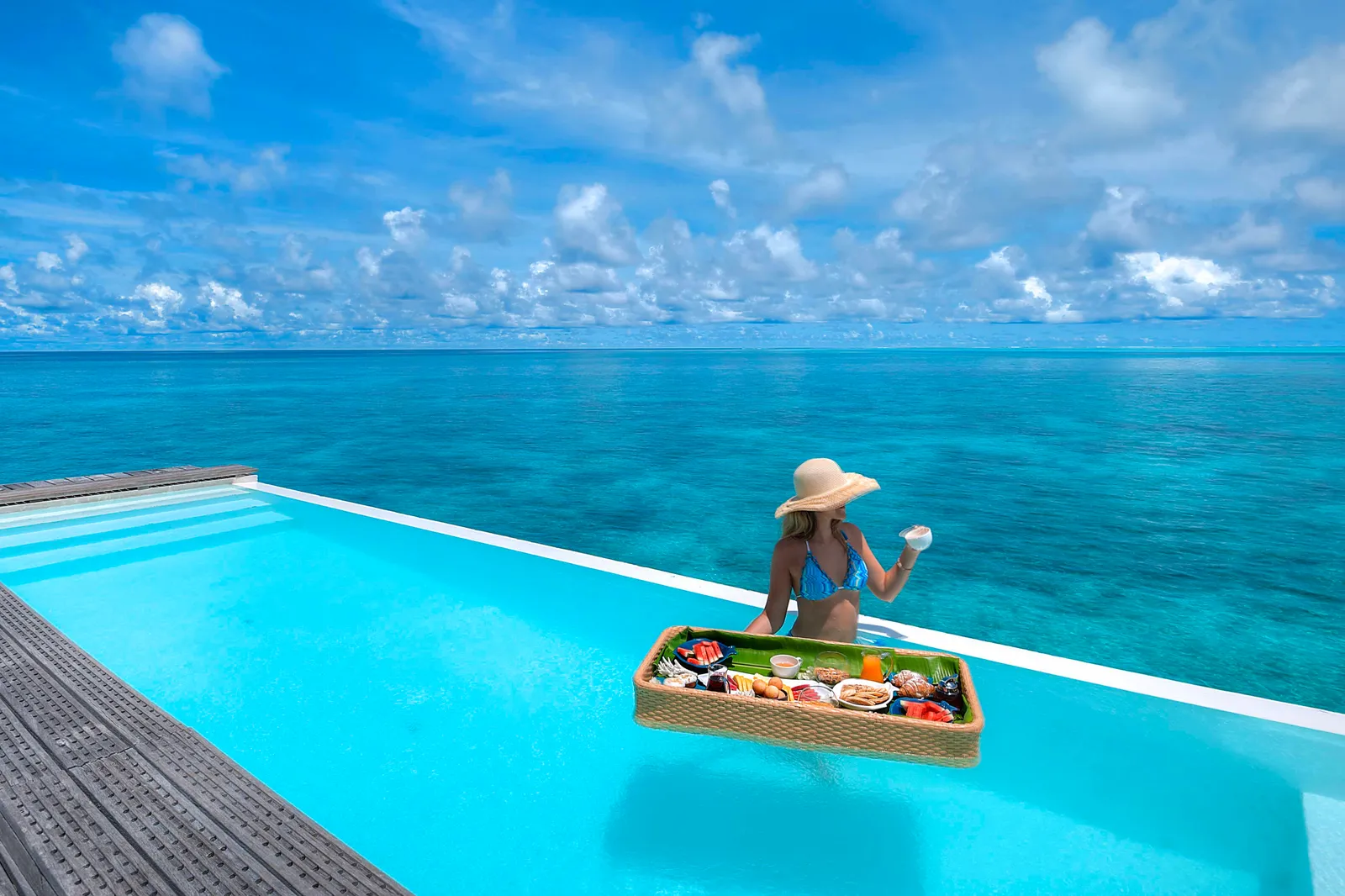 The pool on a Two Bedroom Pool Water Villa’s deck, with a floating breakfast and the open sea.