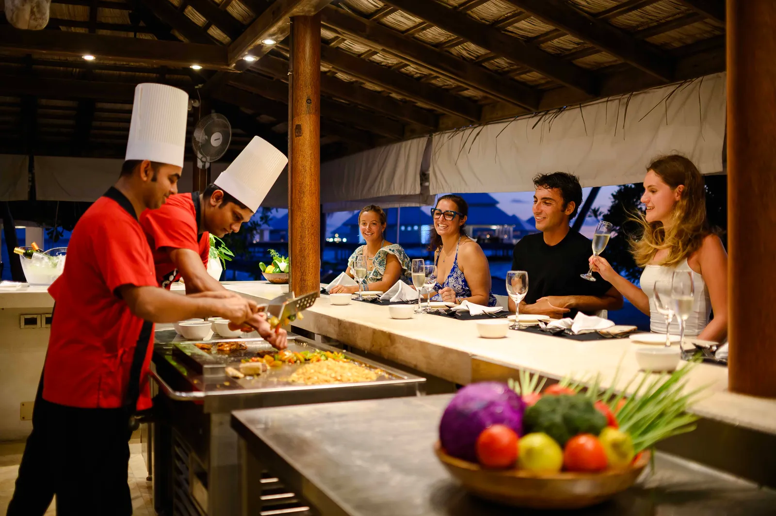2 chefs at the teppanyaki grill, in front of 4 guests at the counter.