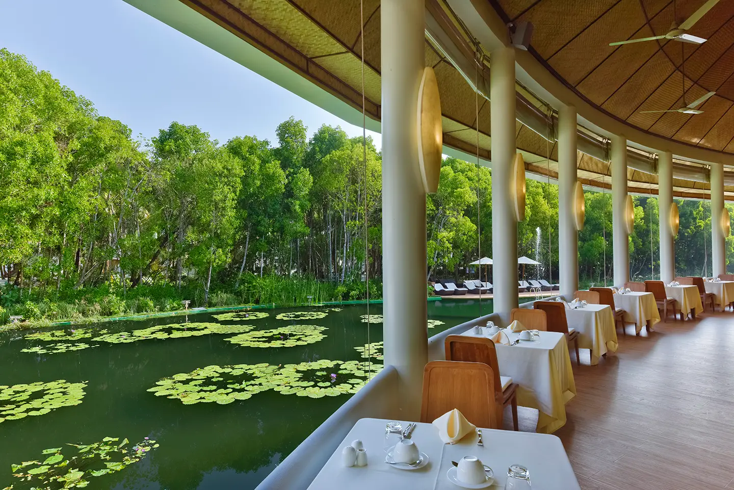 The Lake View Restaurant’s terrace over the lake, its tables laid under the thatched roof and the mangroves opposite.