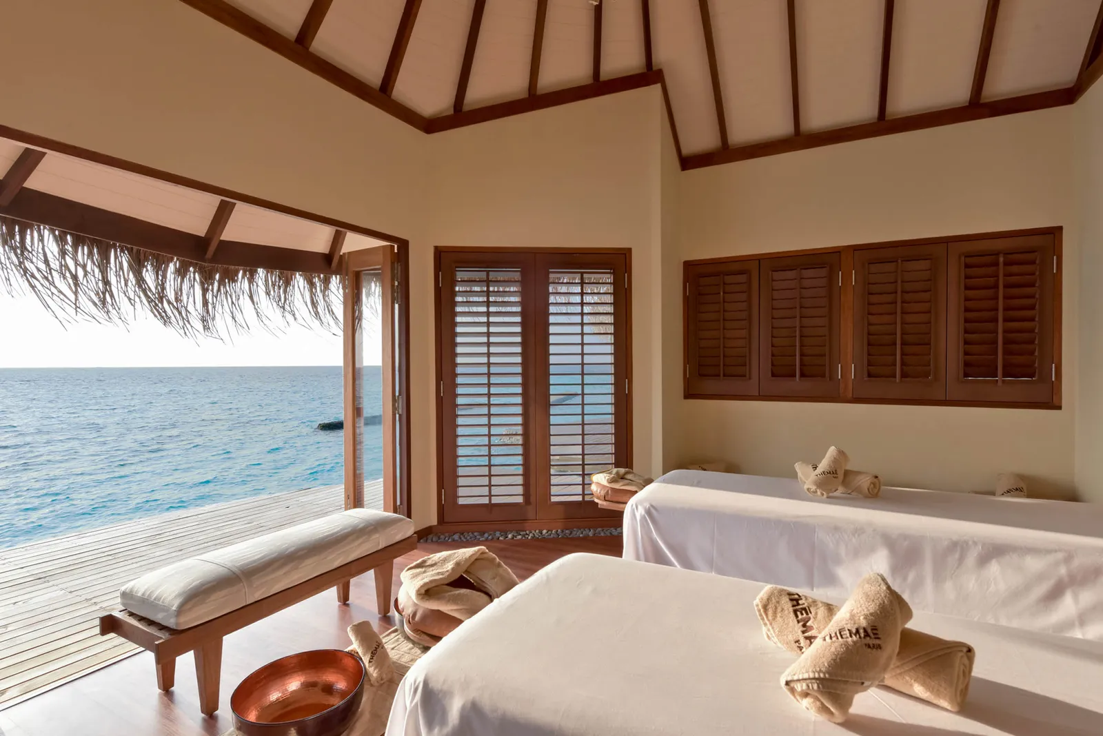 An overwater spa room, with 2 massage couches and the deck open to the ocean.