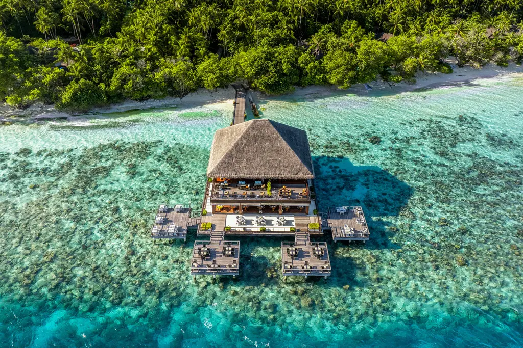 Benjarong from above: the Thai restaurant on stilts over the reef, joined to the beach by a jetty.