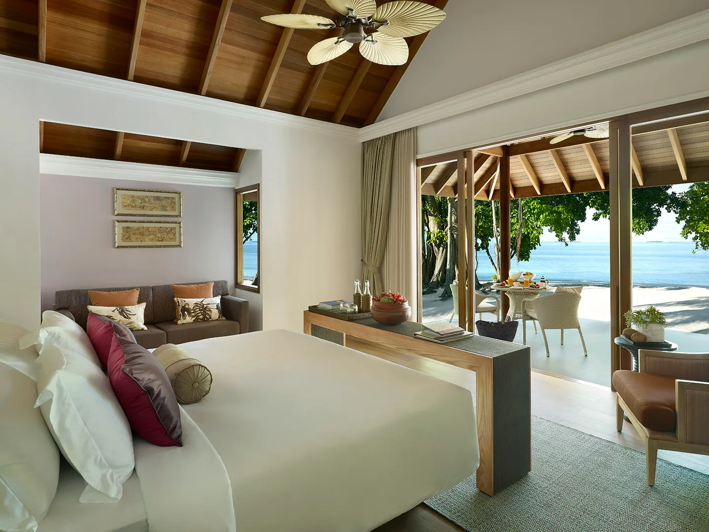 A Beach Villa bedroom, with the bed, the desk and doors open to the terrace.