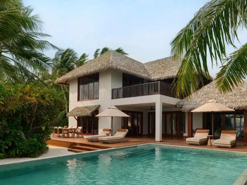 The 2-storey Two Bedrooms Beach Pool Residence, with its pool, loungers and palms.