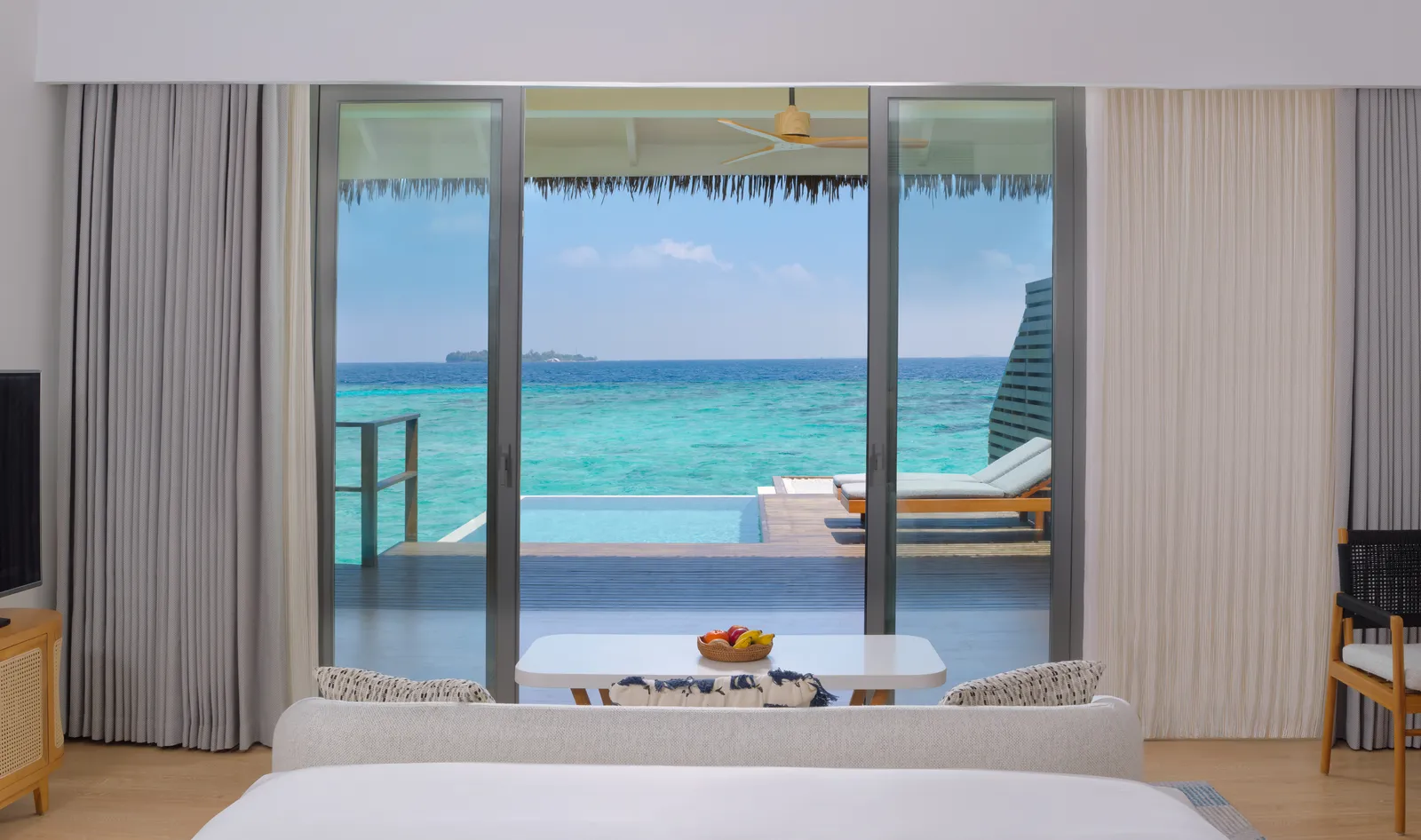 A Waterfront Pool Villa: from the bed, the deck, the private pool and the ocean, with a ship on the horizon.