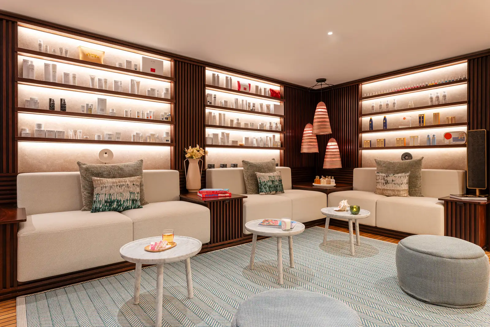 The spa’s sitting room: pale sofas, round tables and lit shelves lined with products.