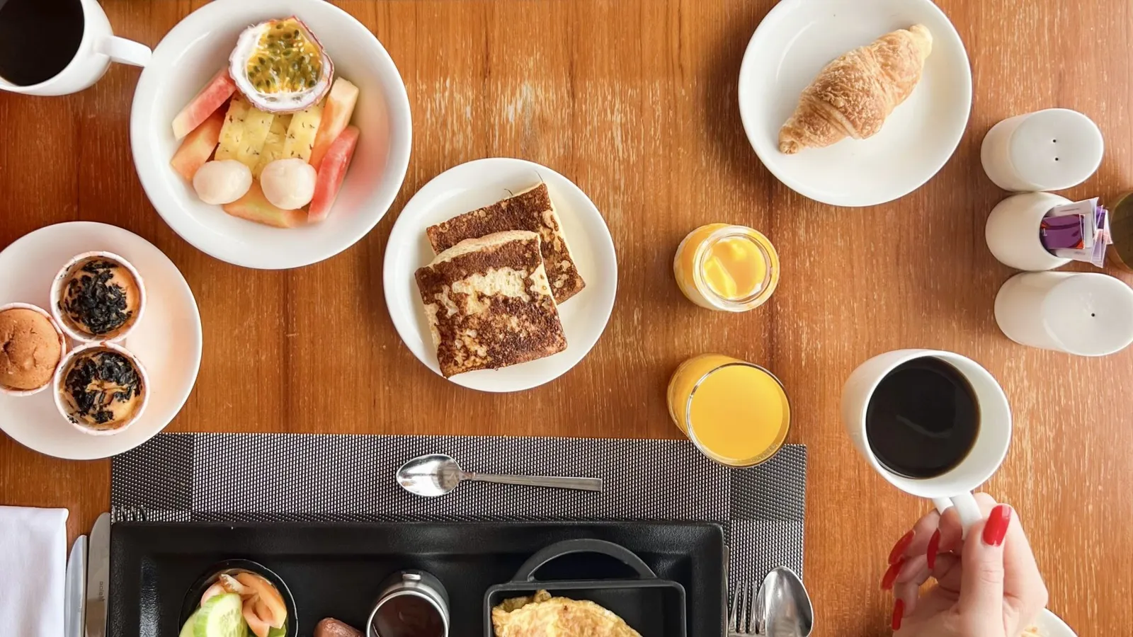 A breakfast from above: fruit, pastries, coffee and orange juice