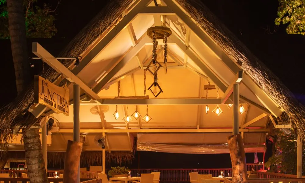A thatched pavilion lit up in the evening