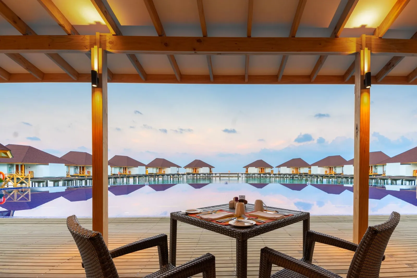 A table laid on the deck, the Water Bungalows ahead