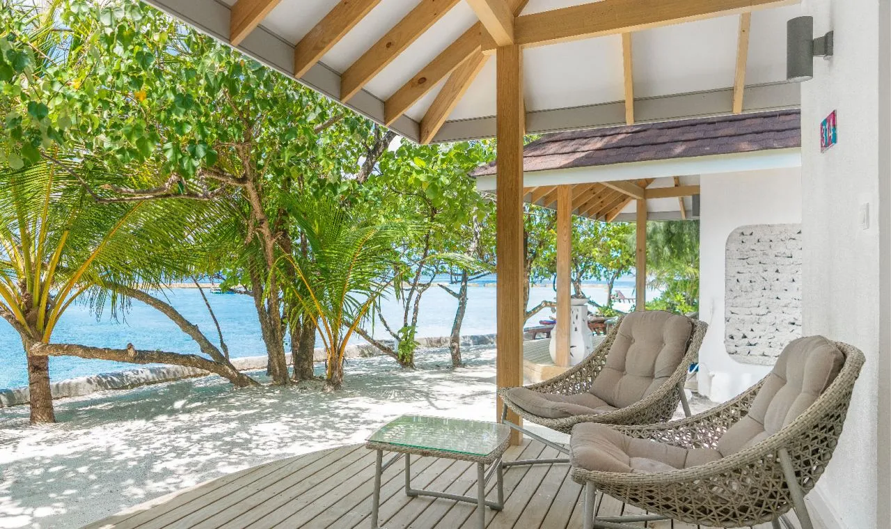 A Beach Bungalow’s deck on the sand, chairs facing the sea