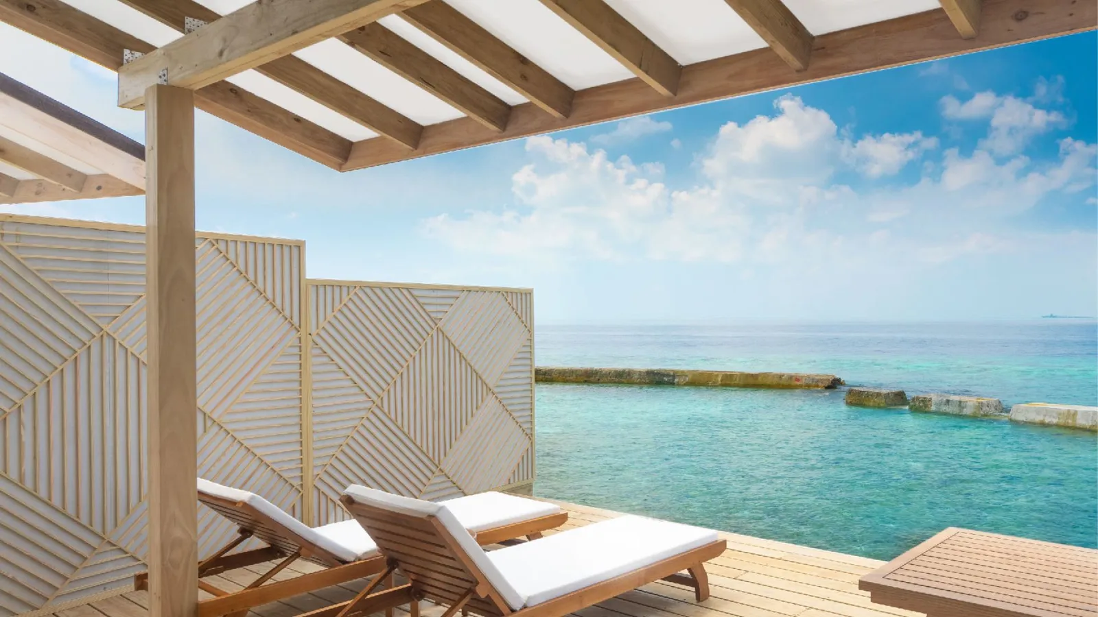 A Water Bungalow’s deck, the loungers above the lagoon