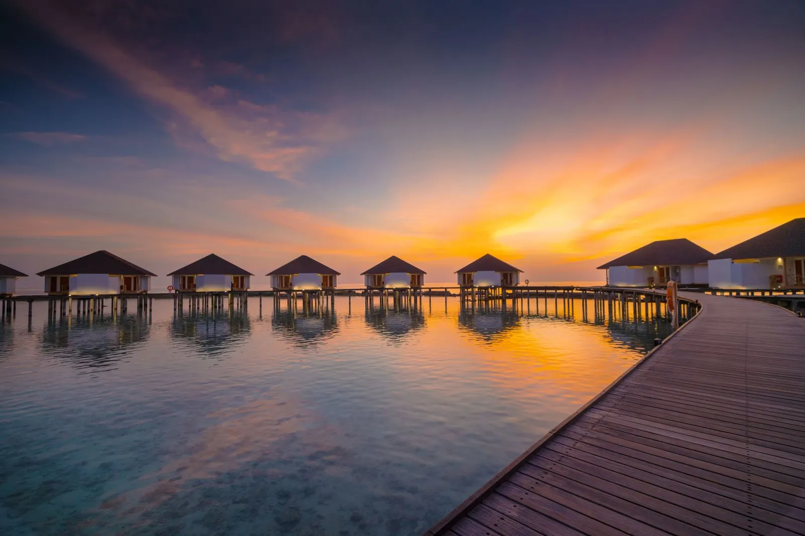 The Water Bungalows at sunset, the wooden walkway over still water