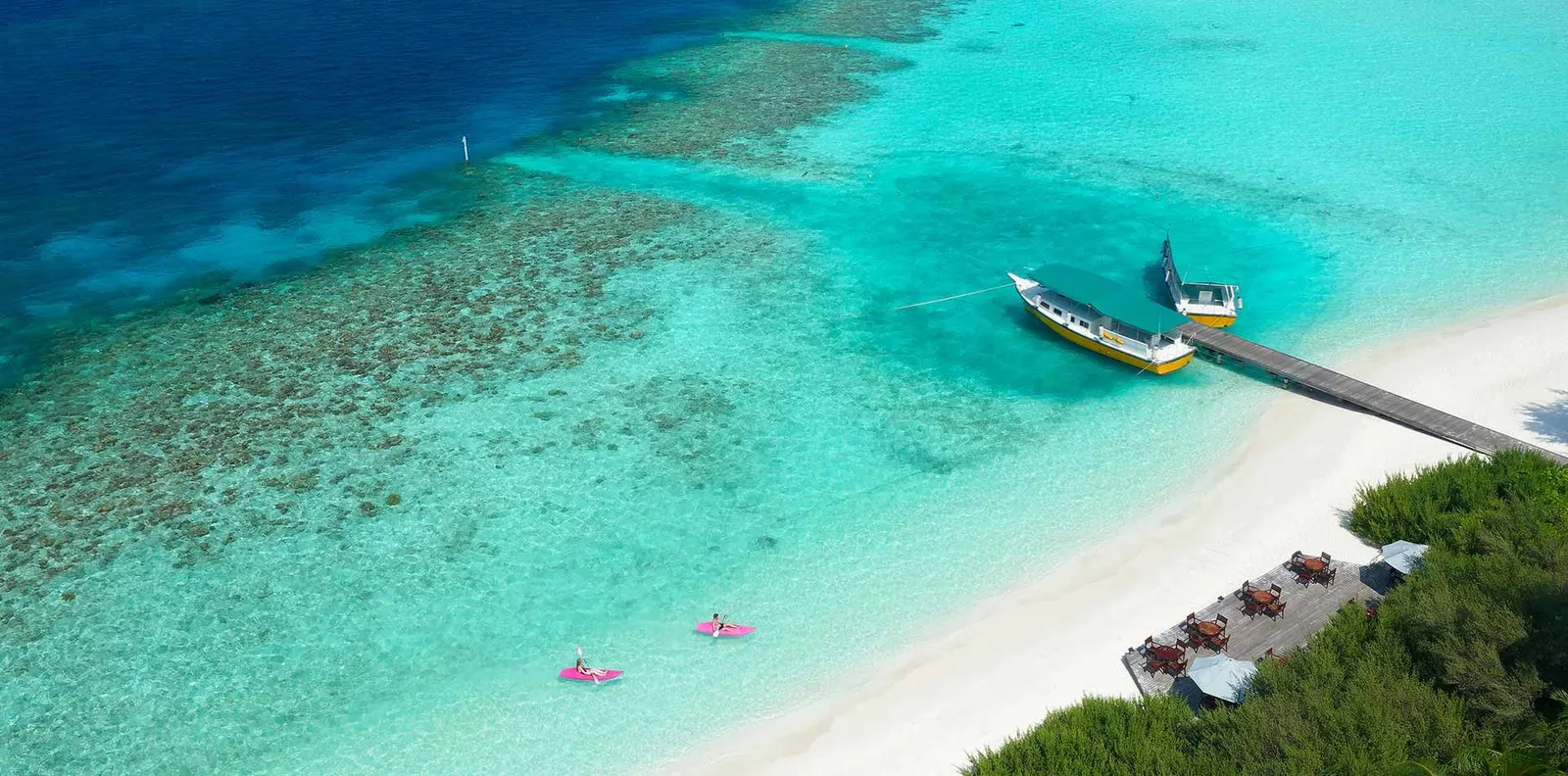 Embudu from the air: the jetty with a dhoni moored, the white sand, the turquoise lagoon over the reef and 2 floating mats.