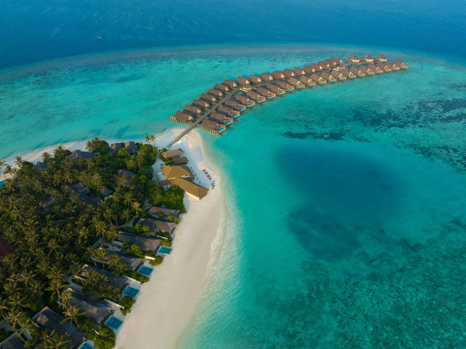 The beach villas among the palms, the spit of sand running into the lagoon and the water villas in a line offshore.