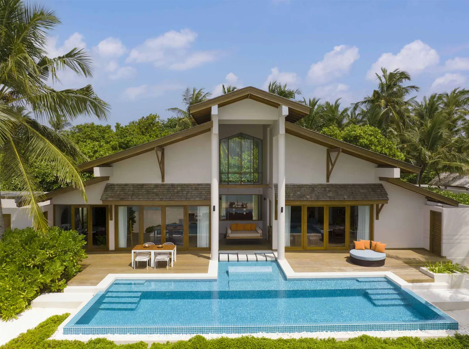 The front of the Presidential Beach Villa with its large pool, among the palms.