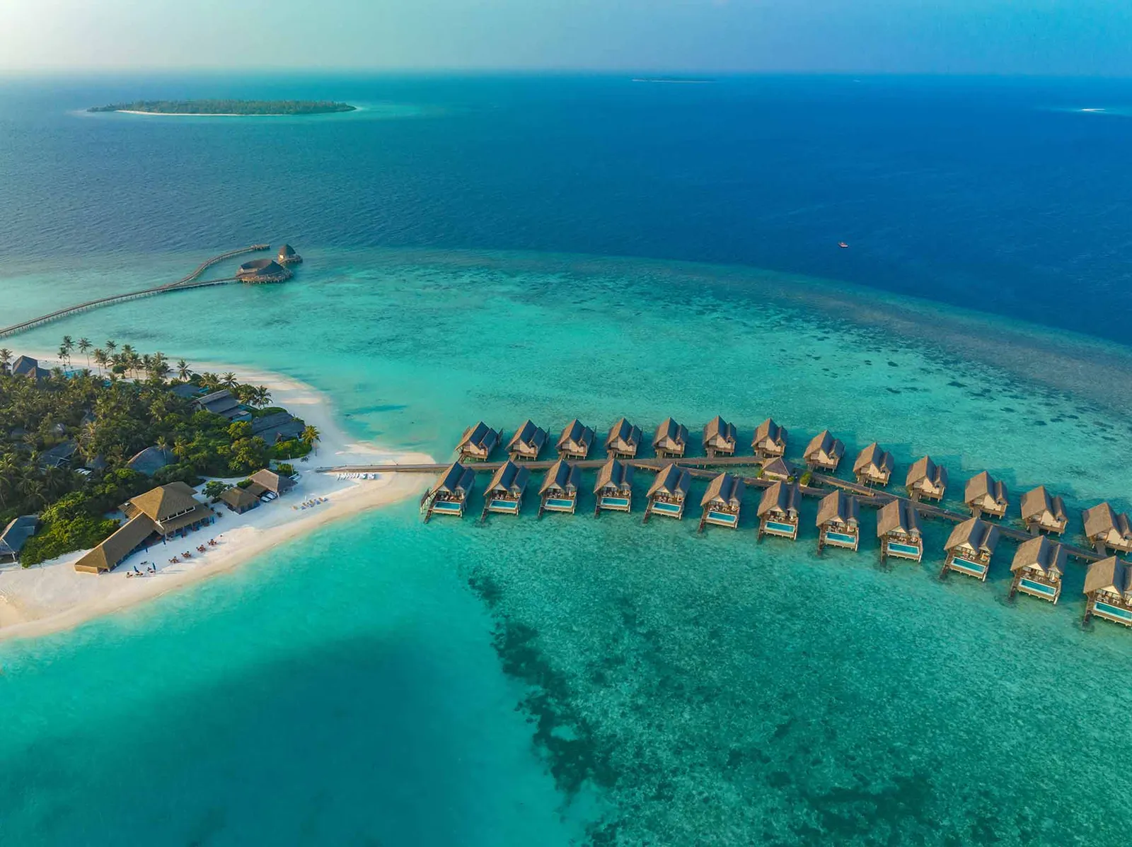 The water villas from above, in a double row on the lagoon, with the beach and the island’s greenery to the left.