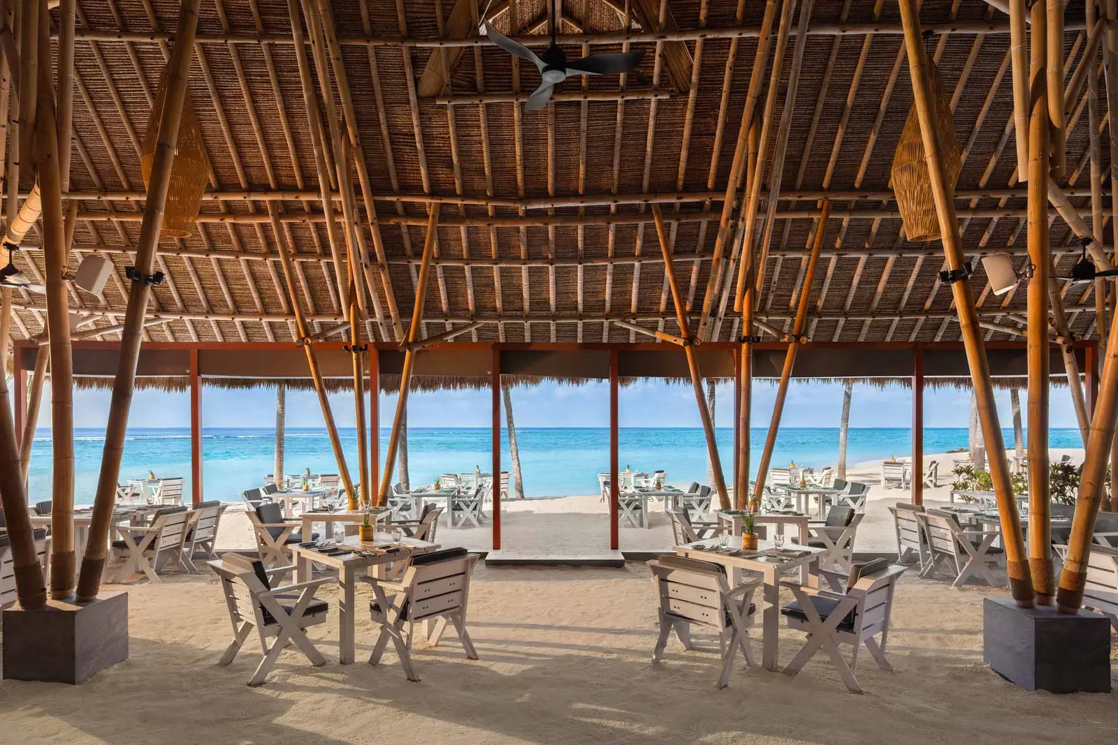 The Beach Club Grill’s dining room under its thatched roof, open to the beach and the sea.