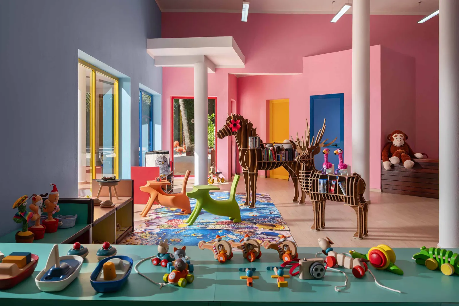 The Dolphin Kids Club playroom, with its coloured walls, the wooden horse, soft toys and toys in a row.