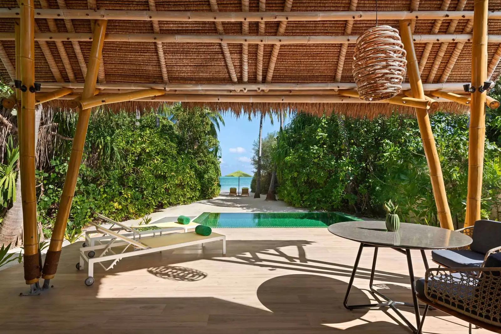 A Beach Villa with Pool’s covered deck, with its table, the private pool and the path to the sea.