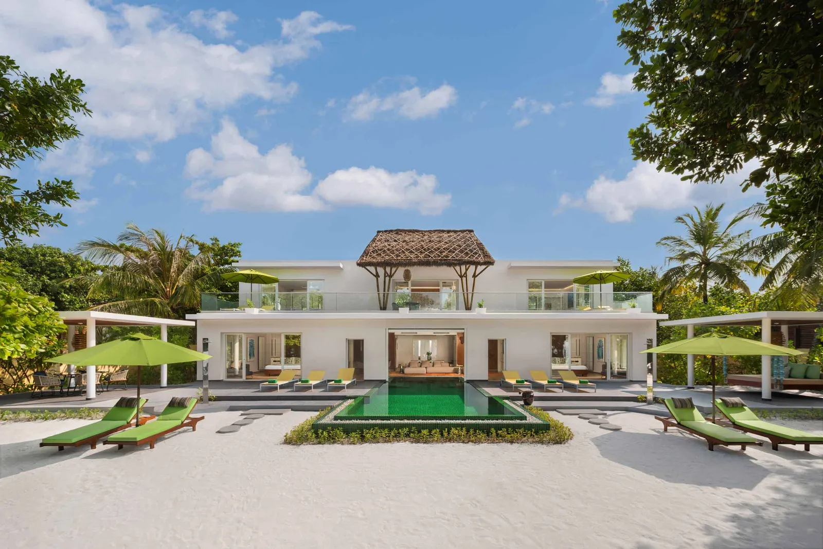 The 2-storey Royal Beach Villa, with its pool, green loungers and parasols on the sand.