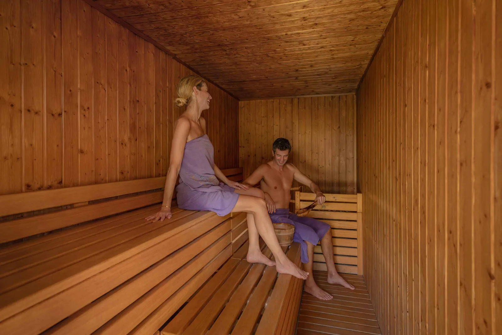 The Emerald Spa’s timber-lined sauna, with a couple seated on the benches.