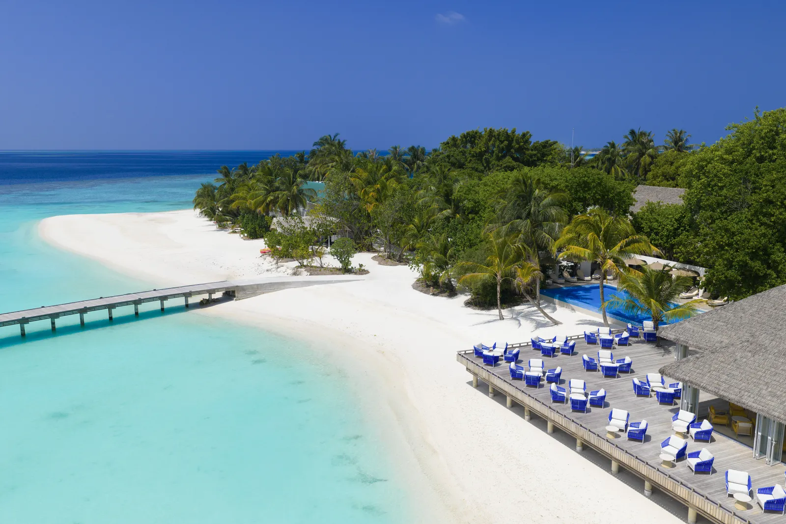 The long white beach from above, the jetty over the lagoon and Sip & Dip’s deck with its blue loungers under the palms.
