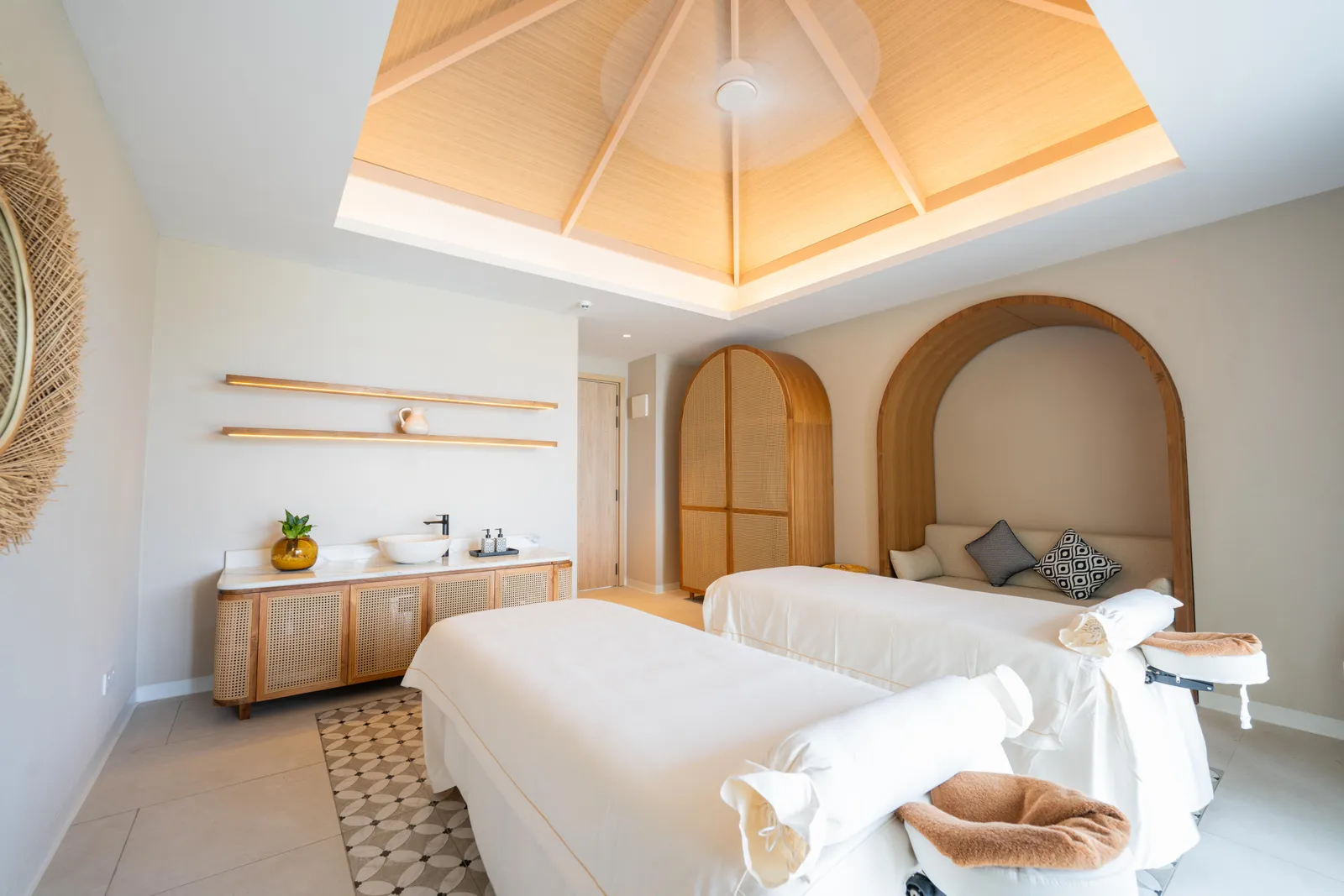 A double treatment room at Eskape Spa, with 2 massage beds, arched alcoves and a timber ceiling.