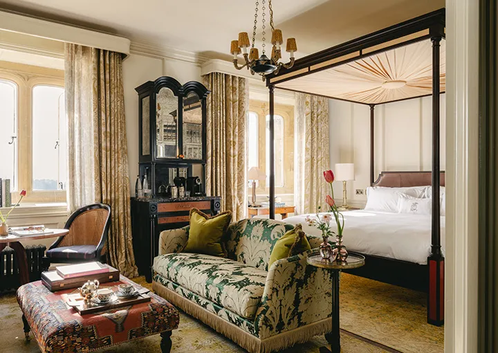 An Estate Suite: the sitting area with a floral sofa and the four-poster beyond