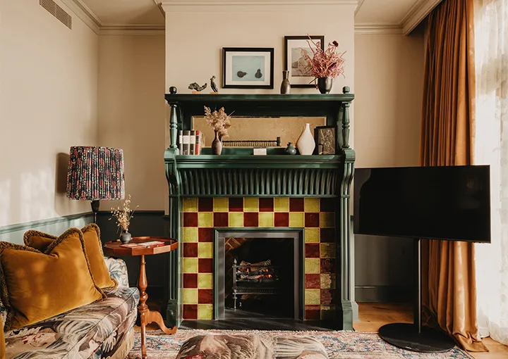 A Large Stable Room: the fireplace with yellow and red tiles and the floral sofa