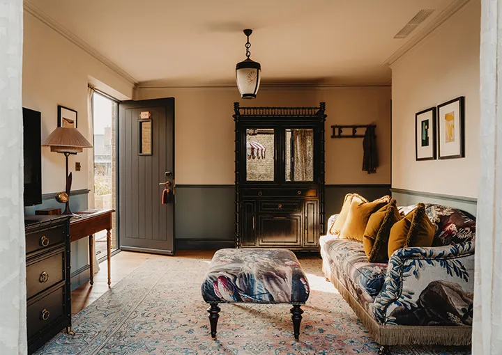 A Large Stable Room with private courtyard: the sofa, a patterned ottoman and the door to the courtyard