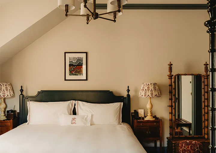 A Stable Room with private terrace: the bed under the sloping ceiling and a bamboo mirror