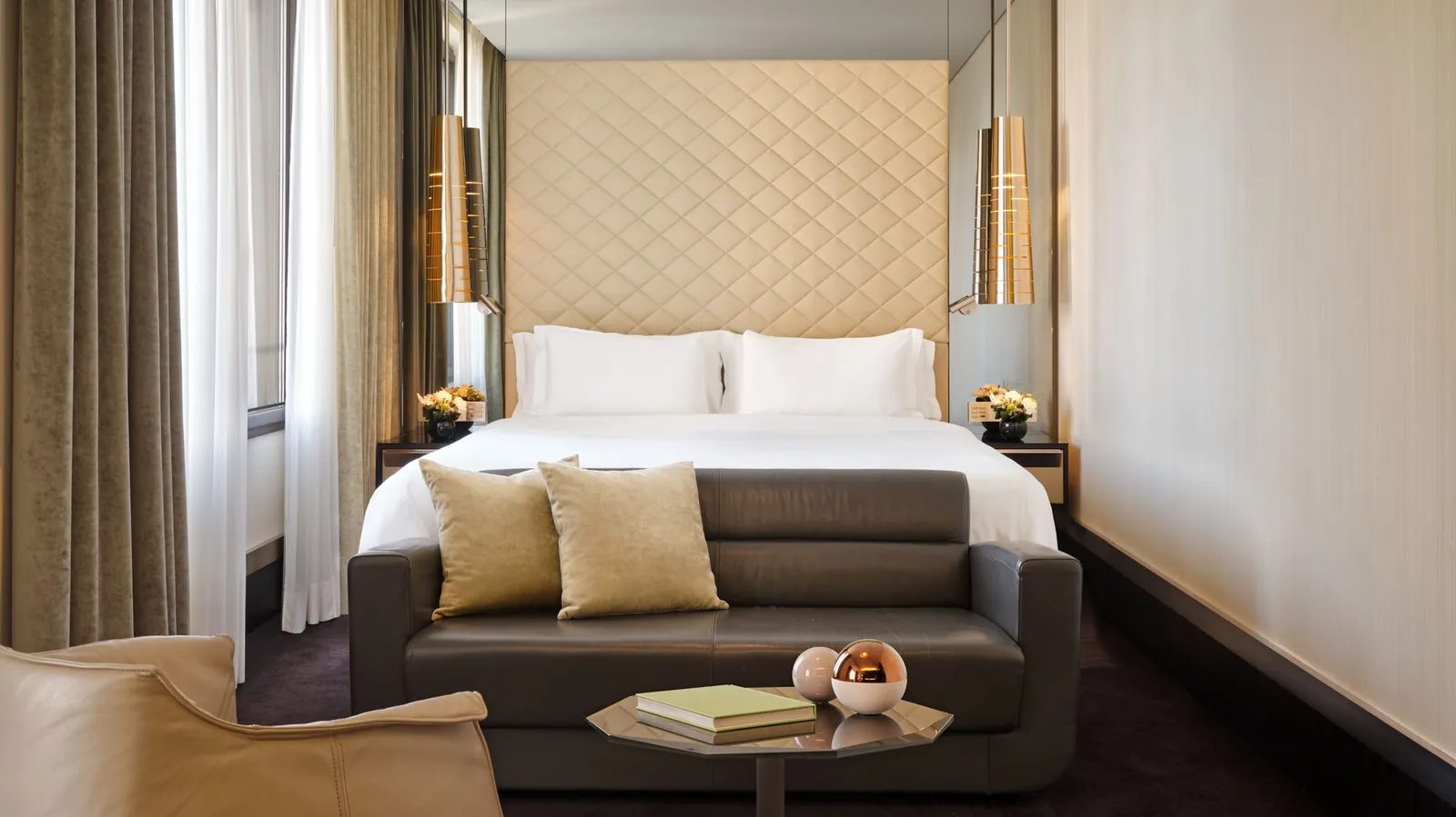 An Excelsior room, with the bed, a leather sofa and a coffee table